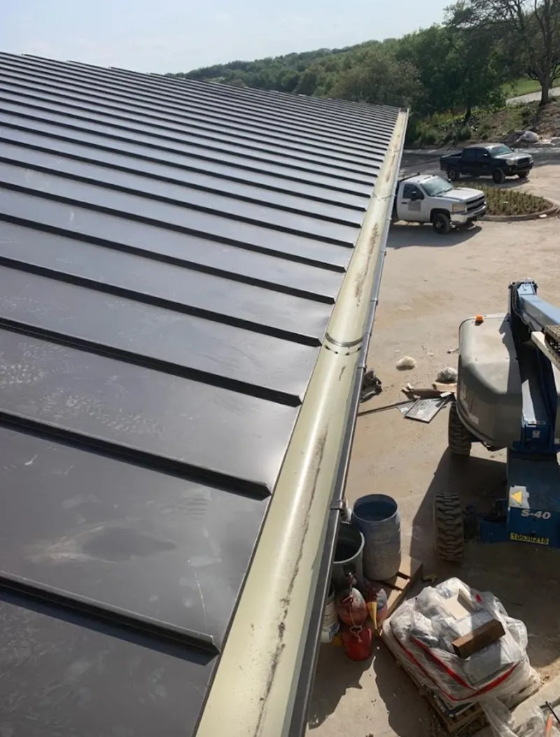 Standing seam panel and gutter detail on a metal roofing jobsite in Albany